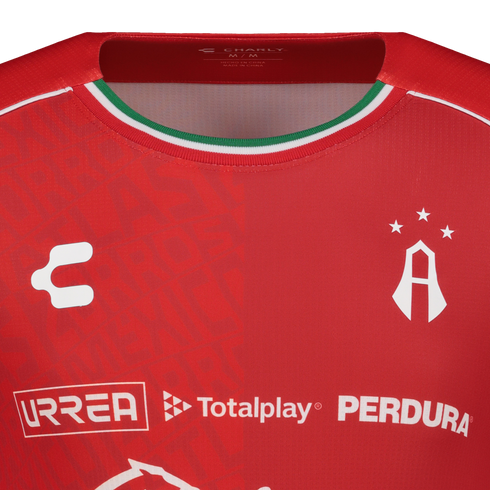 Close-up of a red Atlas FC soccer jersey by Charly, featuring sponsor logos and a Mexican flag-colored collar trim.