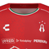 Close-up of a red Atlas FC soccer jersey by Charly, featuring sponsor logos and a Mexican flag-colored collar trim.