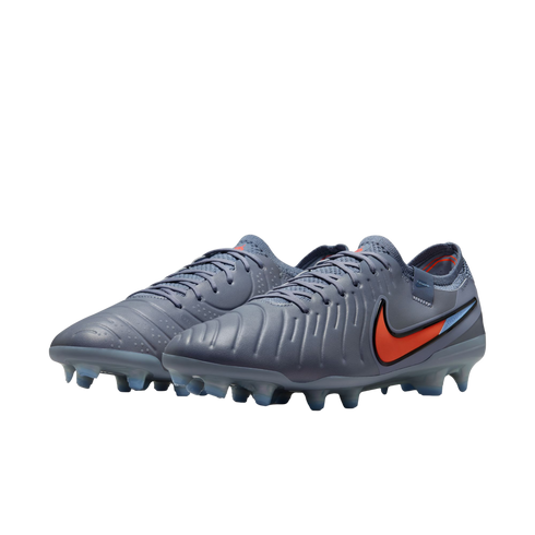 A pair of grey Nike Tiempo soccer cleats with a bright orange swoosh and blue-tinted studs, shown against a solid black background.
