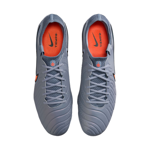 Top-down view of grey Nike Tiempo soccer cleats with bright orange interiors and grey laces, shown against a black background.