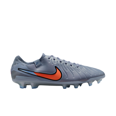 A slate grey Nike Tiempo soccer cleat with an orange and black swoosh and translucent studs, shown in profile against a black background.