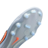 Close-up of the light grey soleplate of a soccer cleat, featuring light blue translucent studs and an orange Nike swoosh against a solid black background.