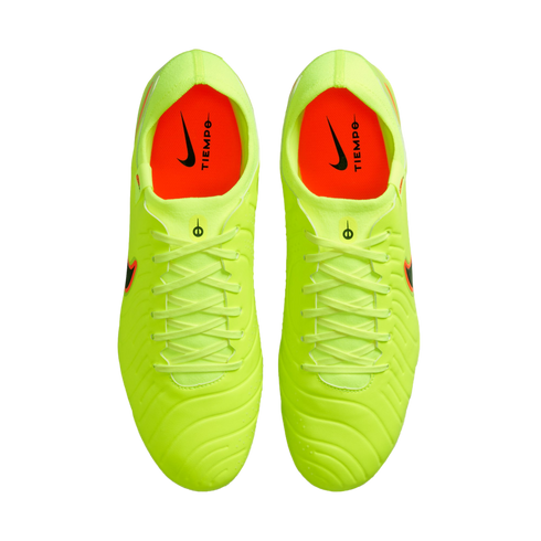Top-down view of neon yellow Nike Tiempo soccer cleats with bright orange interiors against a black background.