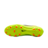 Underside of a lime green Nike soccer cleat with orange studs, set against a black background.
