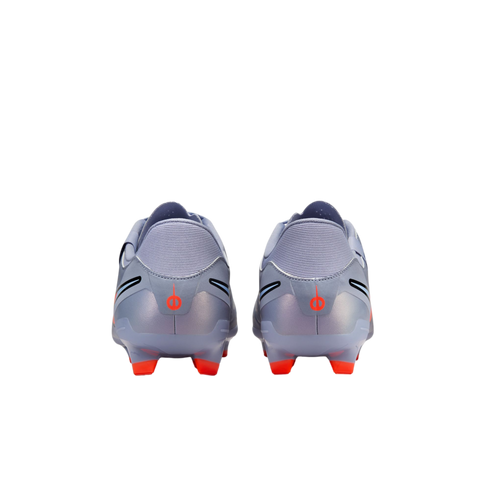 Rear view of a pair of light lavender soccer cleats with metallic heels, orange studs, and small orange logos, isolated against a black background.