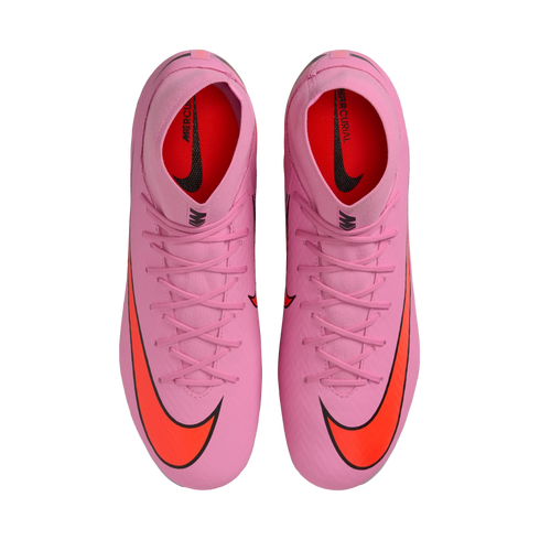 Top-down view of a pair of pink Nike Mercurial soccer cleats with bright orange swooshes on a solid black background.