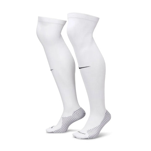 A pair of white knee-high Nike athletic socks with black swoosh logos and grey striped heel and sole patterns, displayed on a white background.