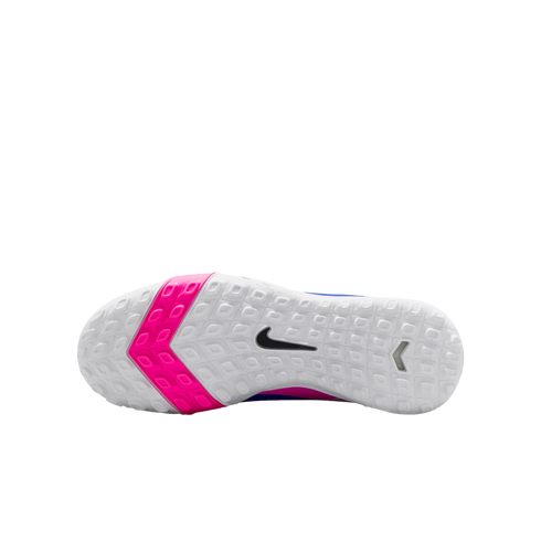 Bottom view of a white Nike shoe with a textured sole, featuring a bright pink chevron band and a black swoosh logo against a black background.