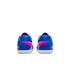 Rear view of blue soccer shoes with bright pink and white accents and white soles on a black background.