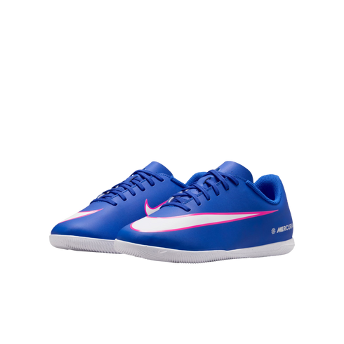 A pair of blue Nike Mercurial indoor soccer shoes with white and pink swooshes, shown against a solid black background.