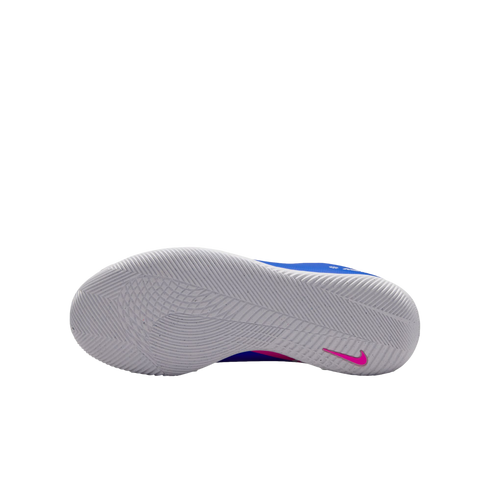 Bottom view of a white Nike shoe sole featuring an intricate tread pattern and a small pink swoosh on the heel, set against a black background.