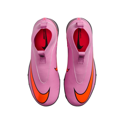Top-down view of a pair of bright pink laceless Nike Mercurial soccer shoes with large orange swooshes against a solid black background.