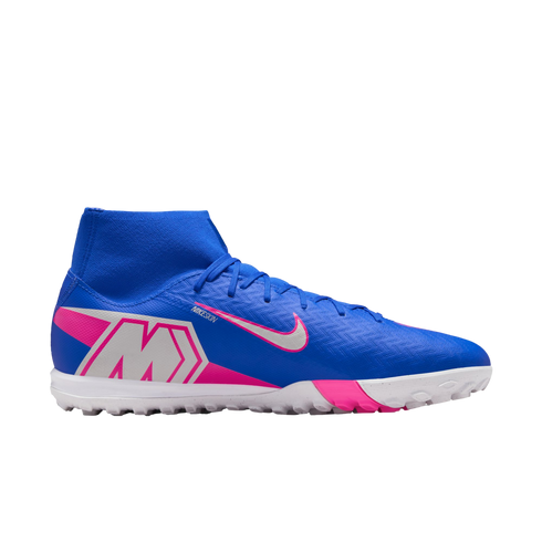 Side profile of a blue Nike Mercurial turf soccer shoe with pink accents, a silver "M" logo, high-top collar, and white lugged outsole.