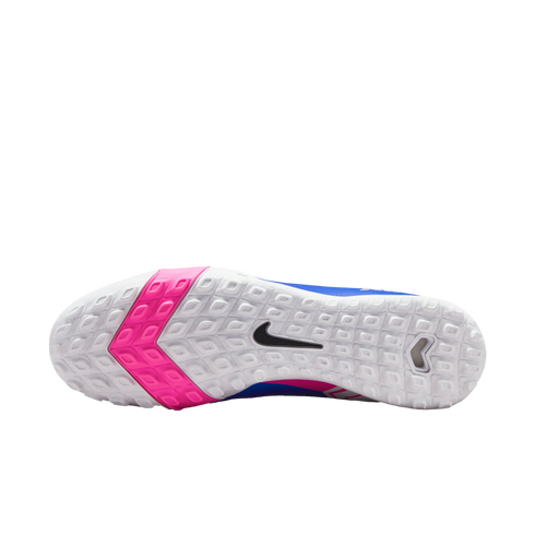 Bottom view of a white Nike soccer shoe sole with pink chevron patterns, small square treads, and a black swoosh logo.