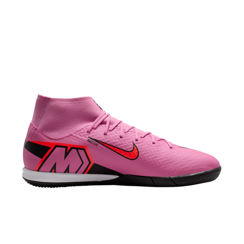 A pink Nike indoor soccer shoe with a high-top sock collar, red Nike swoosh, and large "M" on the heel, shown in profile against a black background.