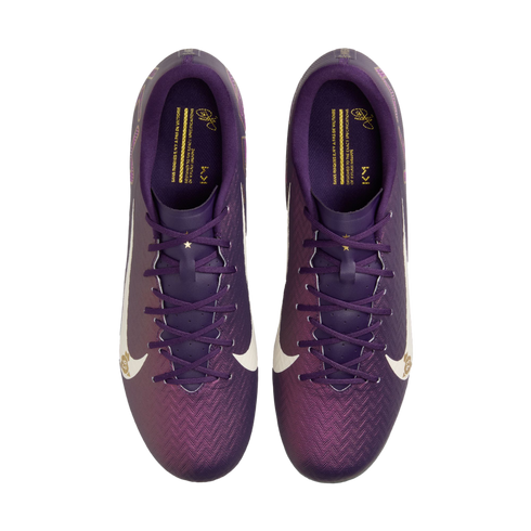 Top-down view of purple Nike soccer cleats with a textured gradient upper, white swooshes, and gold branding on the insoles against a white background.