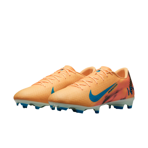 A pair of peach-colored Nike Air Zoom soccer cleats with a blue swoosh and blue studs, set against a solid black background.