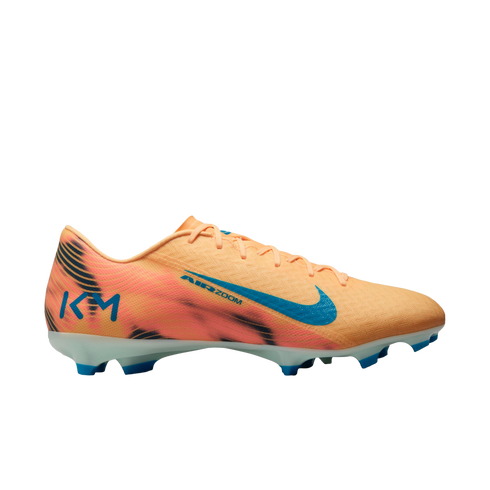 Peach-colored Nike Air Zoom KM soccer cleat with black wavy patterns, a blue swoosh, and blue studs, shown against a black background.