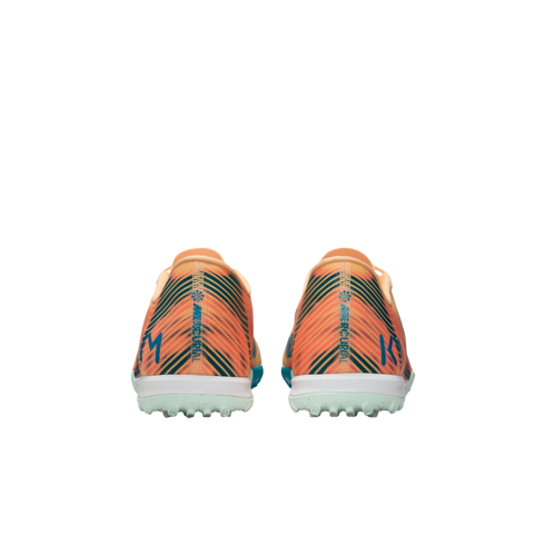 Rear view of orange and teal striped Nike Mercurial turf soccer shoes with "KM" initials on the heels against a black background.