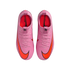 Top-down view of a pair of bright pink Nike Mercurial soccer cleats with large orange swoosh logos and pink laces, set against a solid black background.