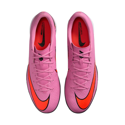 Top-down view of pink Nike Mercurial soccer shoes with orange swooshes on a black background.