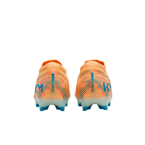 Rear view of two orange Nike Mercurial soccer cleats featuring blue vertical text and "KM" logos on the heels against a black background.