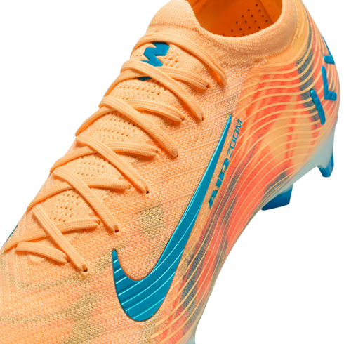 Close-up of an orange Nike soccer cleat with teal accents, featuring a textured knit upper, orange laces, and AIR ZOOM branding.