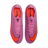A top-down view of vibrant pink Nike Mercurial soccer cleats with large orange swoosh logos on the toes and bright orange interior lining, displayed against a black background.
