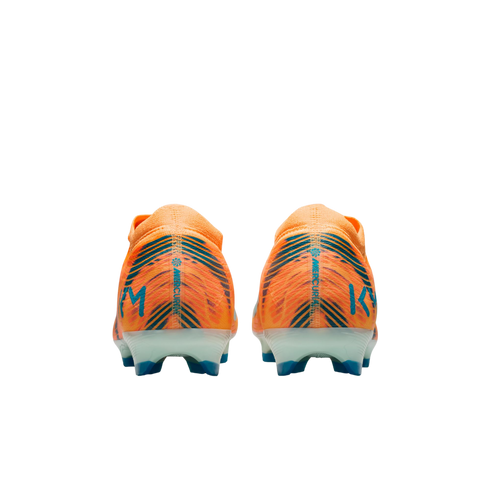 Rear view of two orange Nike Mercurial soccer cleats with blue details and "KM" branding, on a solid black background.