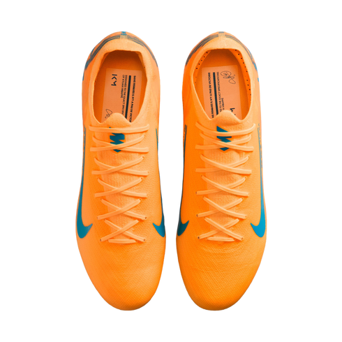 A top-down view of a pair of bright orange Nike soccer cleats with light blue accents and laces, isolated against a solid black background.