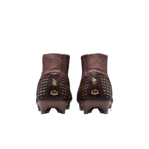 Rear view of two brown and gold Nike soccer cleats with high-top collars and "Zm AIR" logos on the heels, set against a black background.
