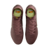 Top-down view of maroon Nike soccer cleats with neon yellow insoles and Kylian Mbappé "KM" branding, set against a solid black background.