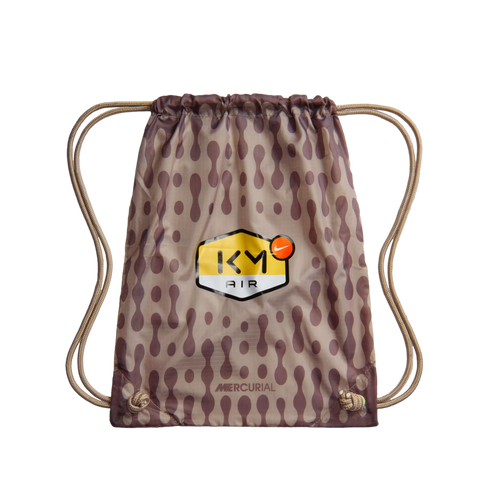 Nike Mercurial drawstring bag in tan and brown pattern, featuring a "KM AIR" logo shield and beige rope straps.