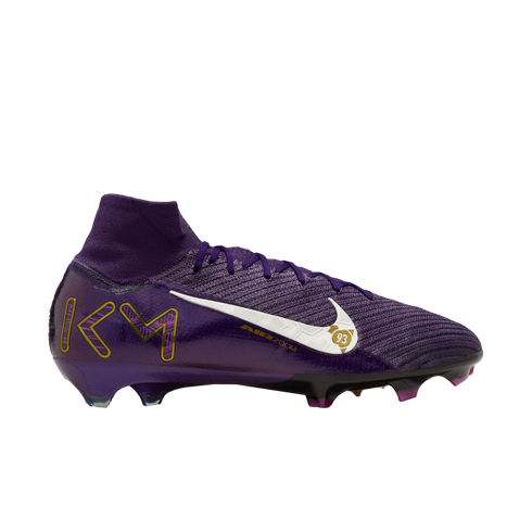 A side profile of a purple Nike football boot with a white swoosh, the letters "KM" in gold, and a high-top sock-like collar.