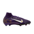 A side profile of a purple Nike football boot with a white swoosh, the letters "KM" in gold, and a high-top sock-like collar.