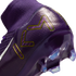 Close-up of a purple Nike Mercurial soccer cleat with a gold KM logo on the heel, featuring a knit ankle collar and clear cleats on the soleplate.
