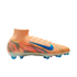 A light orange Nike soccer cleat with a blue swoosh and vibrant red and blue wavy graphics on the side. It features a high-top sock-like collar and blue studs.