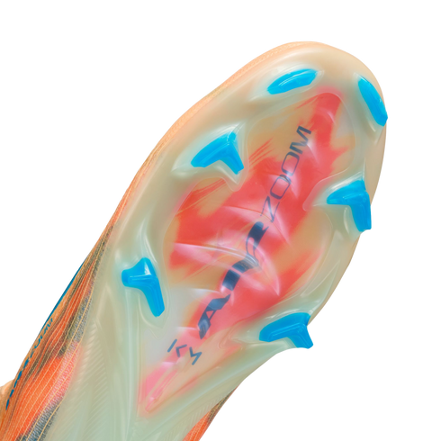 Close-up of a Nike soccer cleat's translucent sole plate with blue studs, featuring a red graphic and "AIR ZOOM" text visible underneath.