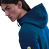 Profile of a person with long hair wearing a dark teal hoodie with a yellow Spotify logo on the sleeve against a black background.