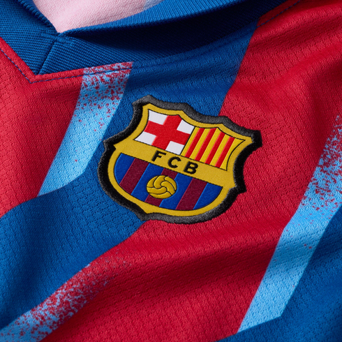 Close-up of a red and blue FC Barcelona soccer jersey featuring the club's embroidered crest on the chest.