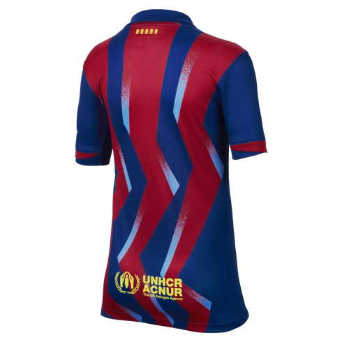 Back view of an FC Barcelona jersey with red and blue zigzag stripes, a small Catalan flag on the collar, and the UNHCR ACNUR logo at the bottom.