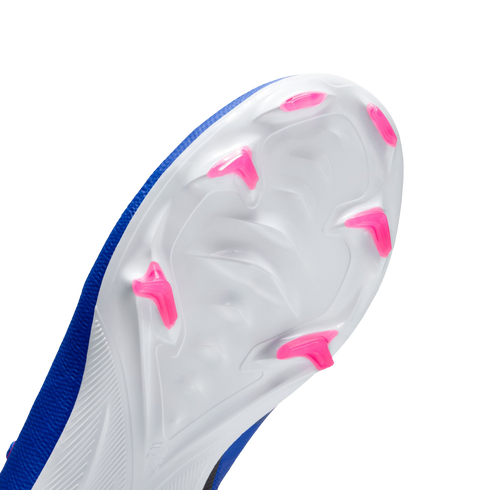 Close-up of the white soleplate of a blue soccer cleat, featuring bright pink chevron-shaped studs against a black background.