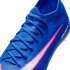Close-up of a textured blue Nike soccer cleat with matching laces and a white swoosh outlined in pink, against a black background.