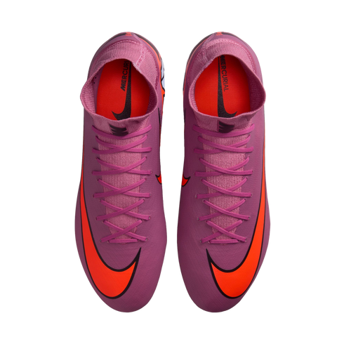 Top-down view of pink Nike Mercurial soccer cleats with bright orange swooshes and high-top collars against a black background.