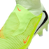 Close-up of a neon green laceless Nike soccer cleat with a textured knit upper and orange and black Nike swoosh logos.