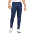 A person wearing navy blue Nike sweatpants with a white logo on the left leg and white athletic shoes.