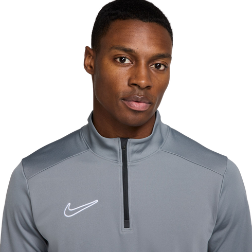 A Black man wearing a grey Nike quarter-zip athletic top against a white background.