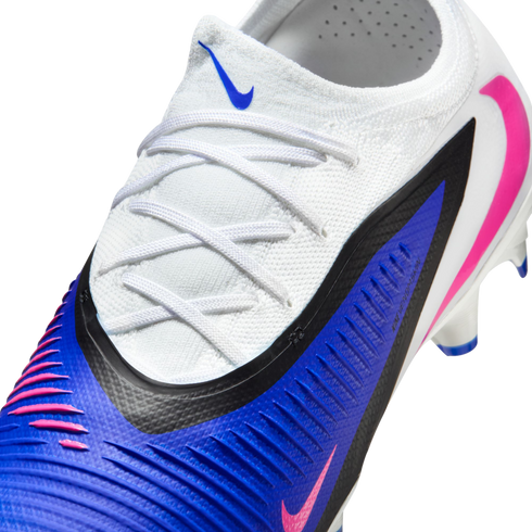 A close-up of a white and blue Nike soccer cleat with pink accents, featuring white laces and a ribbed blue texture.