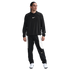 A person wearing a black Nike long-sleeved sweatshirt and black and white track pants with white athletic shoes, standing against a white background.