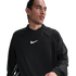 A man wearing a black long-sleeved Nike shirt with a white swoosh logo on the chest, looking to the side against a white background.
